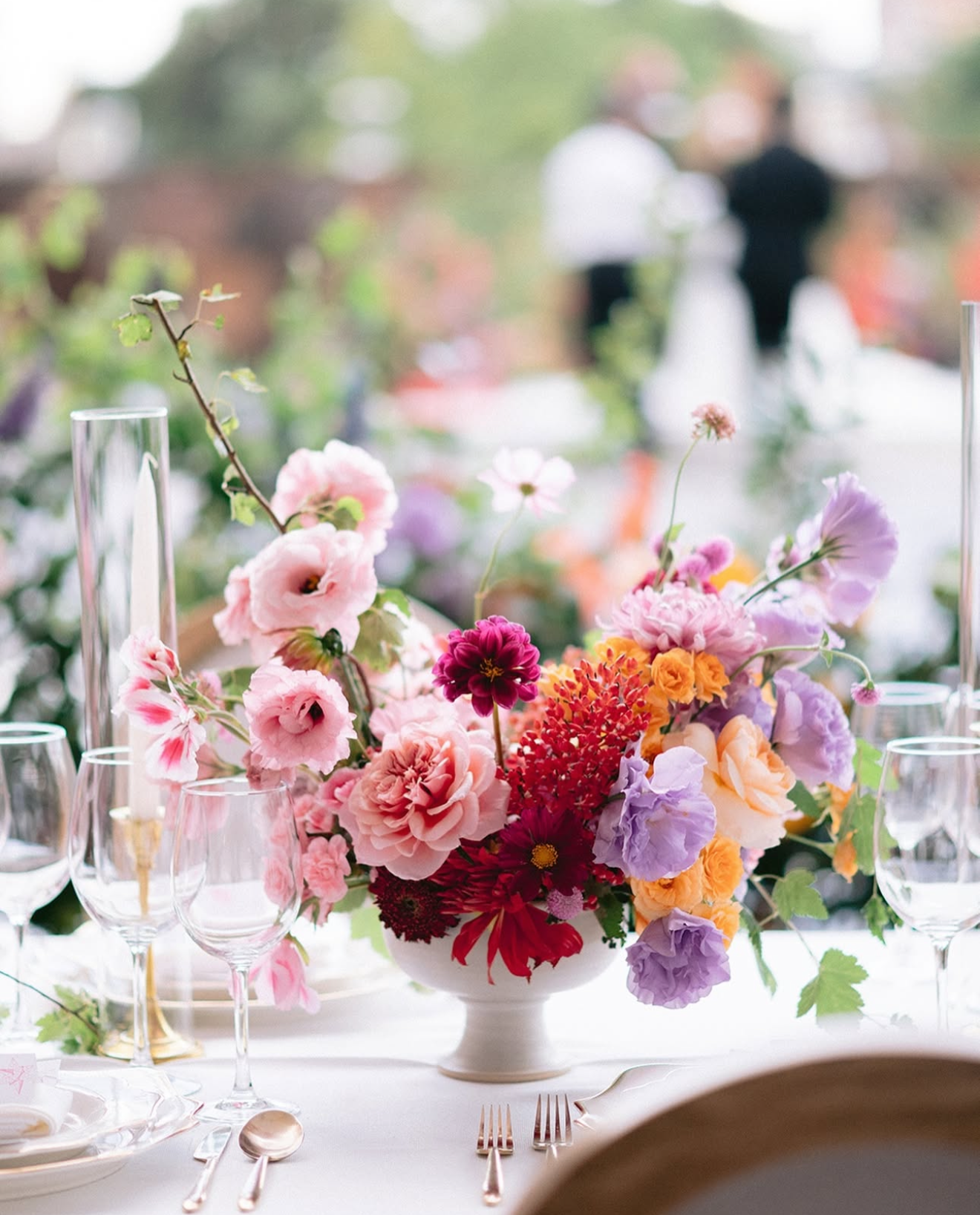 Floral arrangement on a table with blurred people in the background